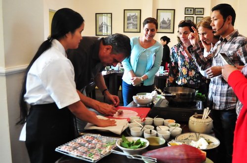 Du khách quốc tế tham gia lớp học nấu các món ăn Việt Nam và trực tiếp làm thử món nem rán